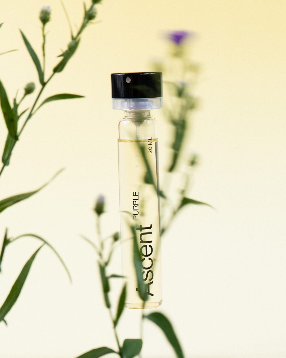 An Ascent perfume refill standing among wild plants and flowers