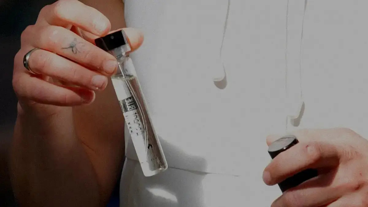 Close-up of hands holding an Ascent perfume bottle