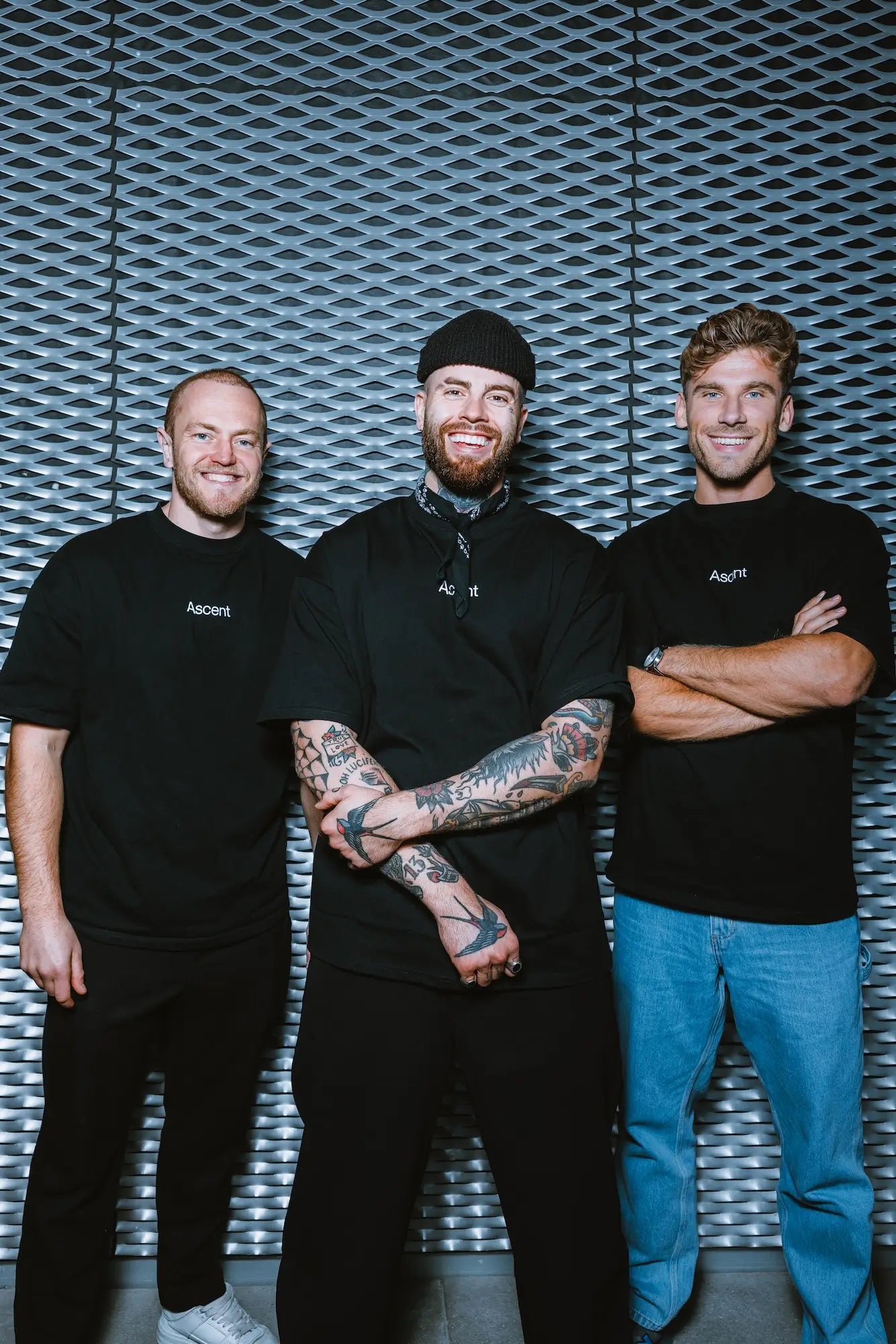 Three Ascent founders standing together against a textured wall.