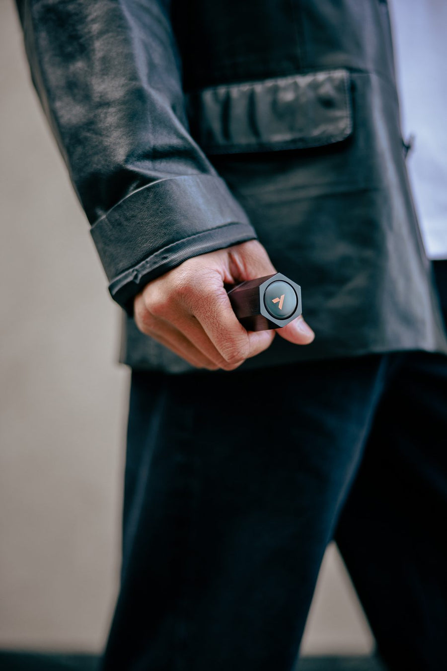 A man in a leather jacket walking with the Ascent case in his hand